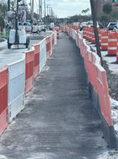 The pedestrian detour channels pedestrians away from the existing sidewalk on the east side of the roadway while crews reconstruct the new sidewalk. February 2026